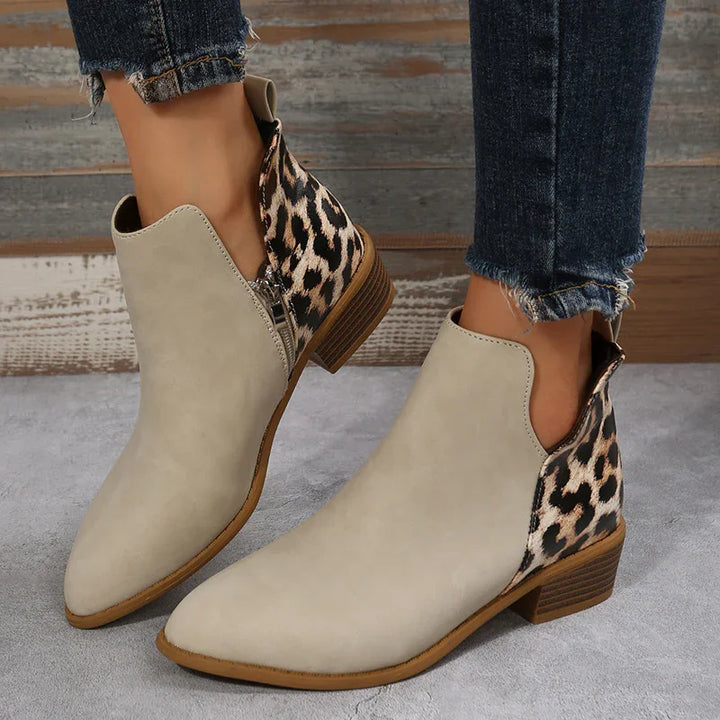 Beige ankle boots with leopard print back panels and low stacked heels worn with frayed dark blue jeans