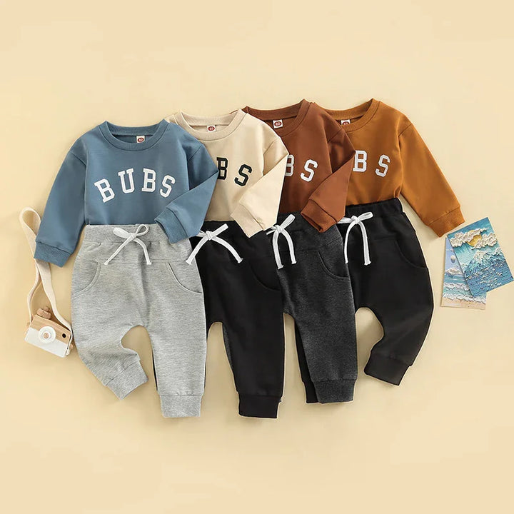 Four toddler outfits with BUBS sweatshirts in blue, beige, brown, and mustard paired with gray and black drawstring pants
