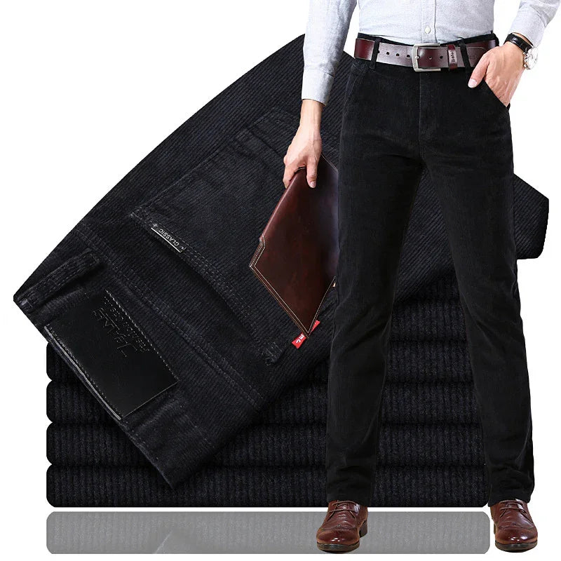 Men's black corduroy pants with brown leather belt, brown shoes, and folded stack of similar pants