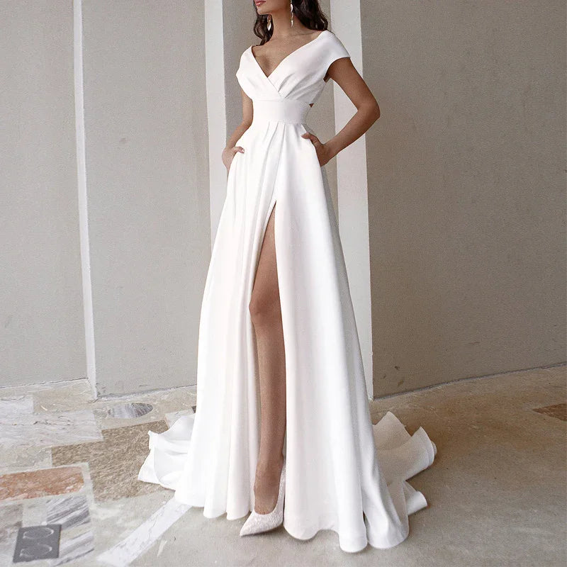 Elegant white off-shoulder evening gown with thigh-high slit and flowing train on model