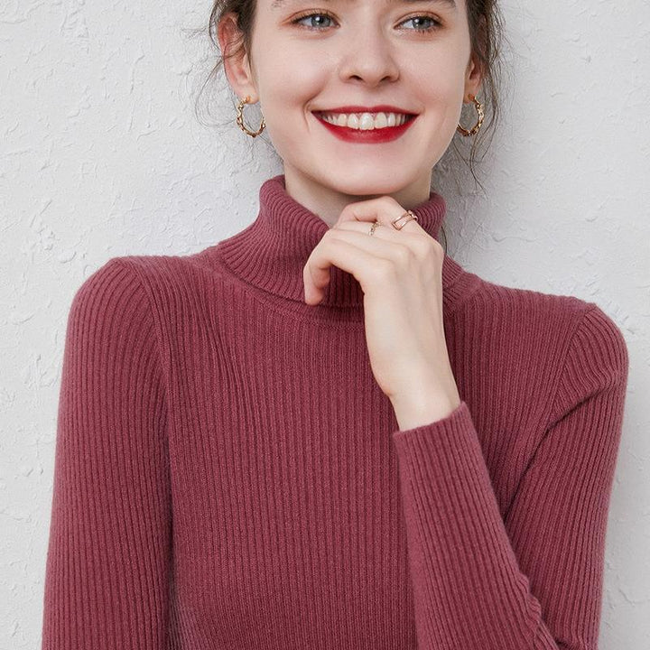 Smiling woman wearing a ribbed burgundy turtleneck sweater and gold hoop earrings