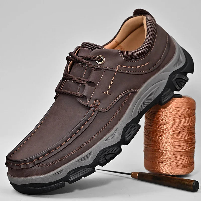 Brown men's casual leather lace-up shoe with thick treaded sole, displayed with orange thread spool and sewing needle