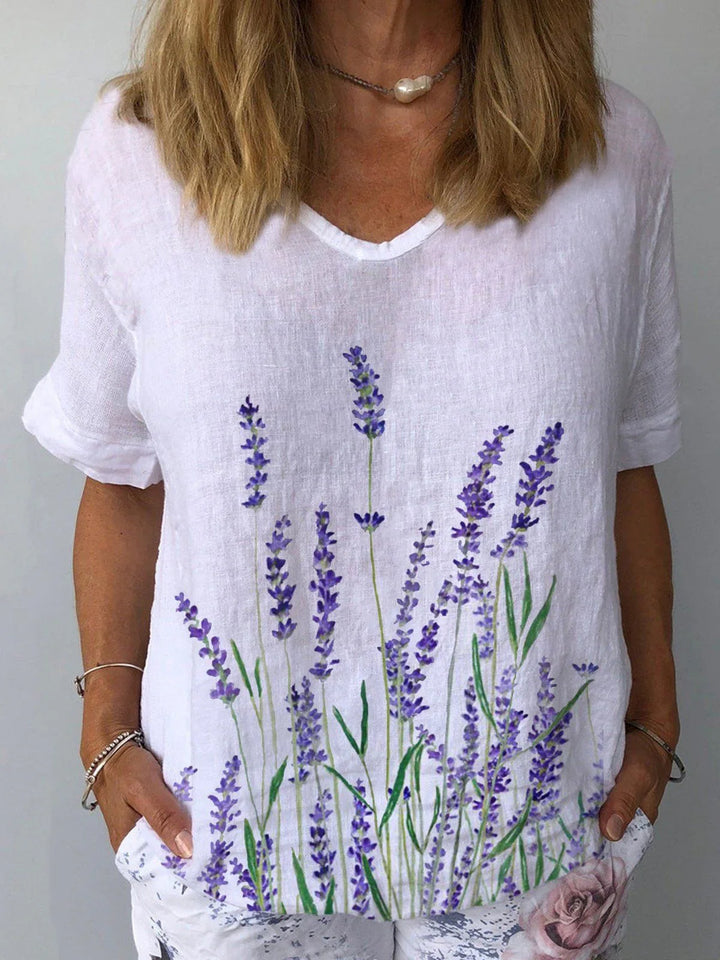 Woman wearing white linen shirt with lavender flower print and casual floral pants