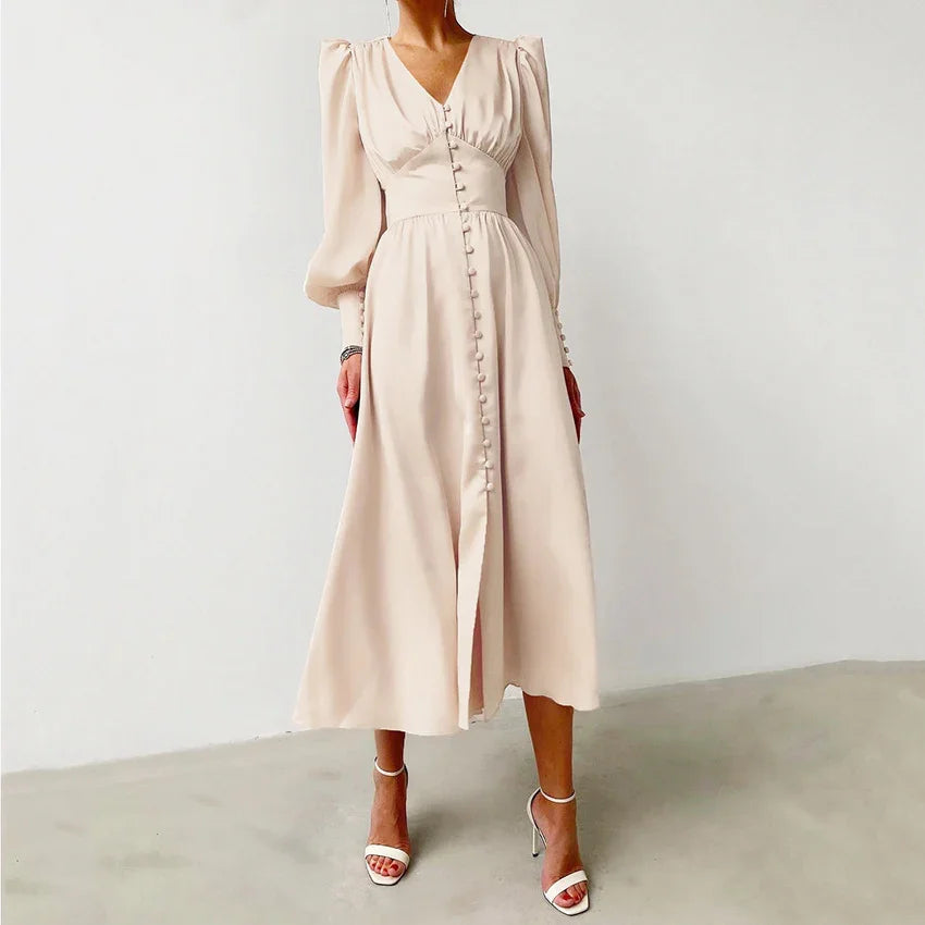 Woman wearing elegant light beige midi dress with long puff sleeves and front button details