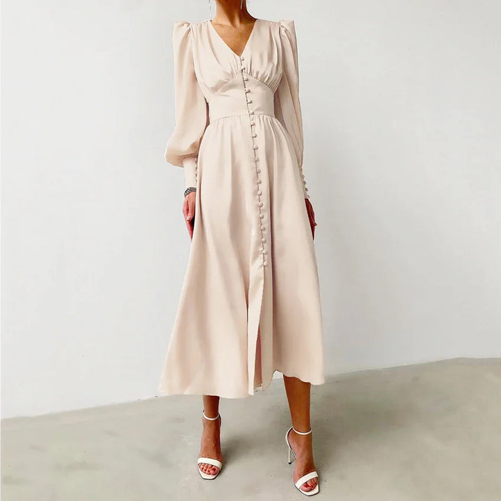 Woman wearing elegant light beige midi dress with long puff sleeves and front button details