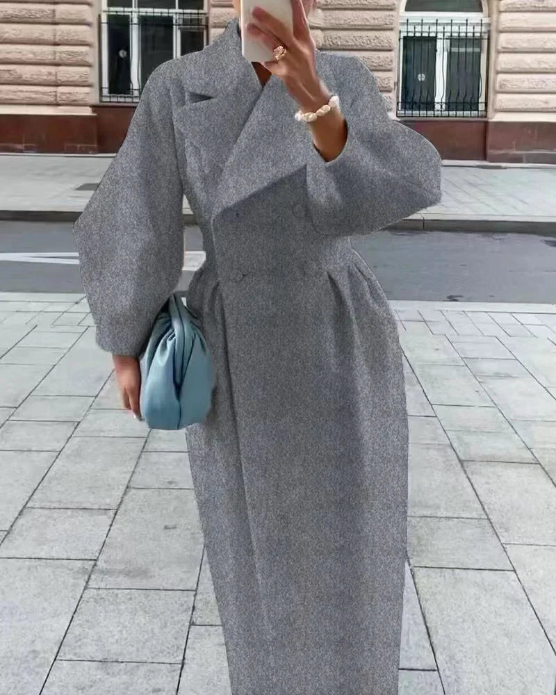 Woman wearing a stylish gray wool coat with puffed sleeves and wide lapels, holding a light blue handbag on city sidewalk
