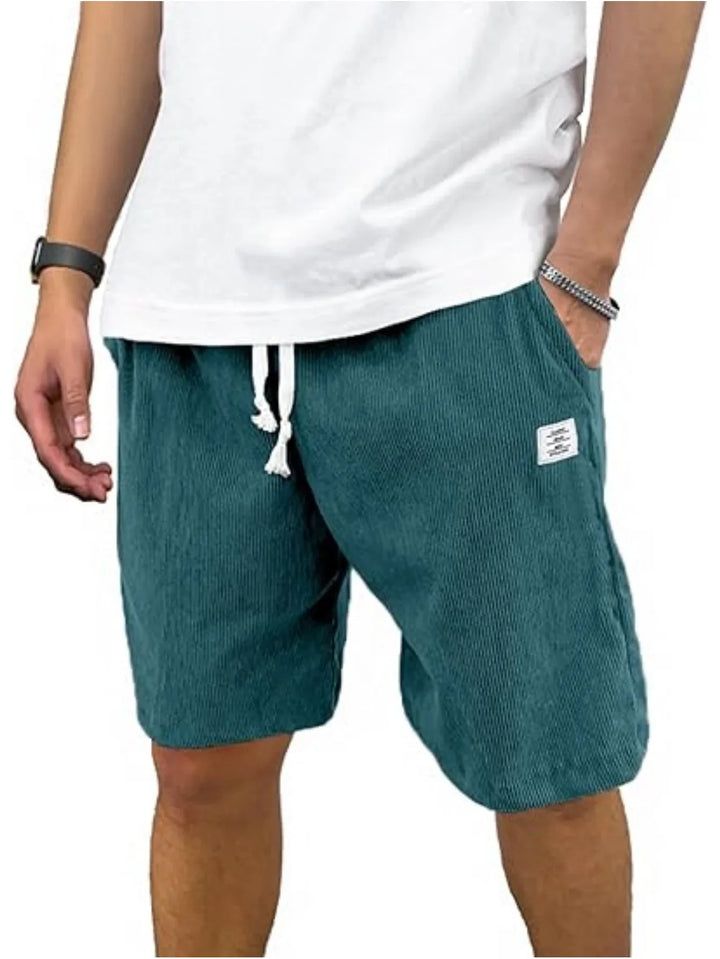 Man wearing teal textured casual shorts with white drawstring and a white t-shirt