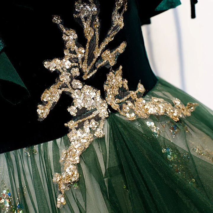 close-up of black and green dress with gold floral sequin embroidery and green tulle skirt