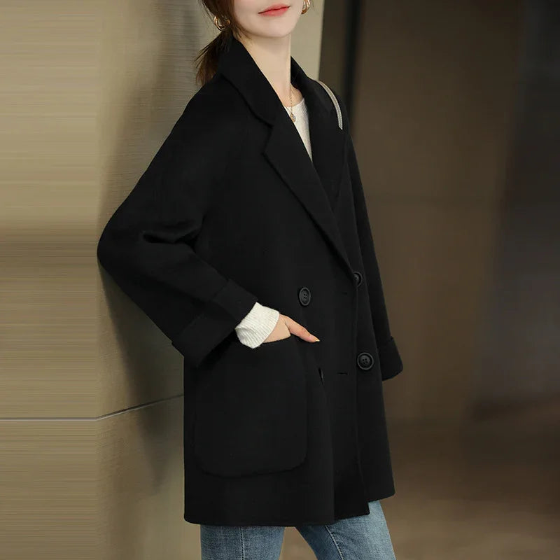 Woman wearing a stylish black double-breasted wool coat with large lapels and front pockets