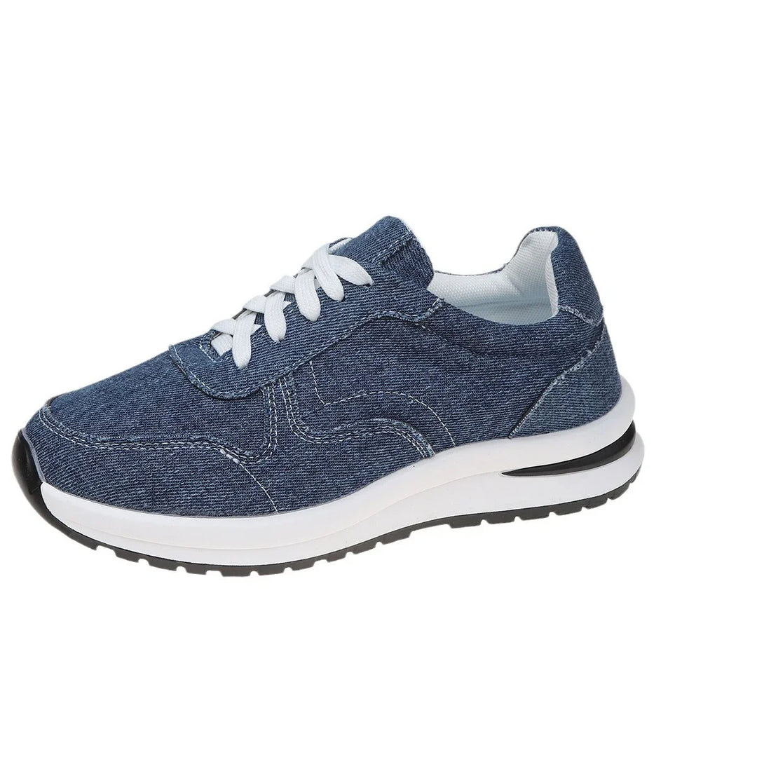 Blue denim sneaker with white laces and cushioned sole on white background