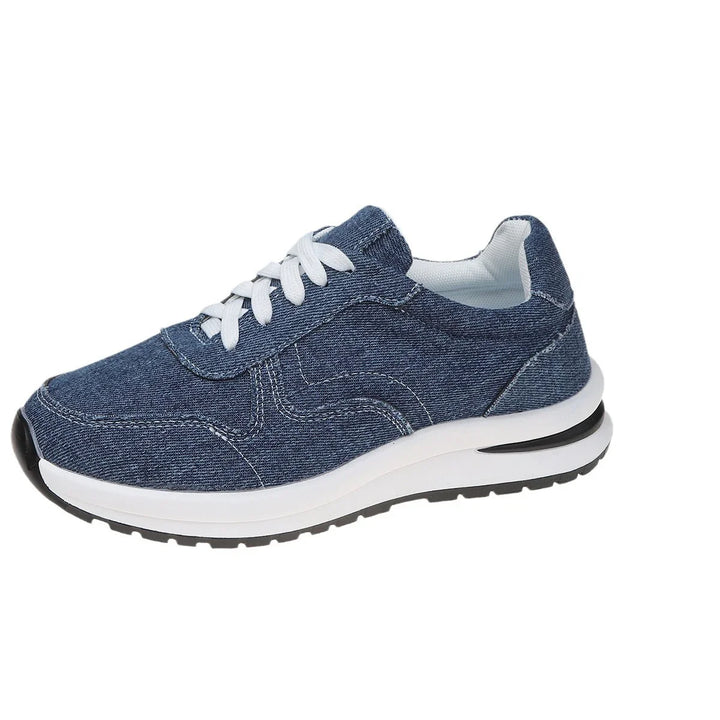 Blue denim sneaker with white laces and cushioned sole on white background