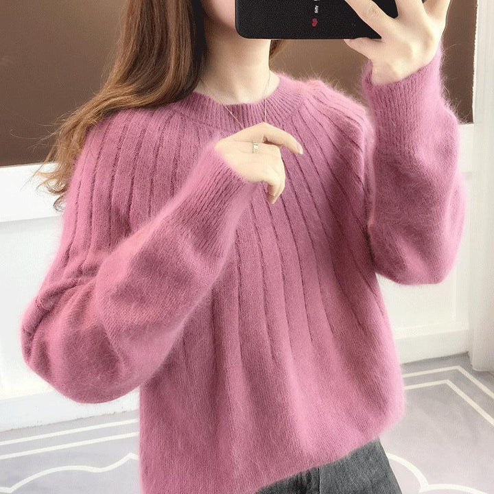 Woman wearing a soft, fuzzy pink ribbed sweater taking a mirror selfie with a smartphone