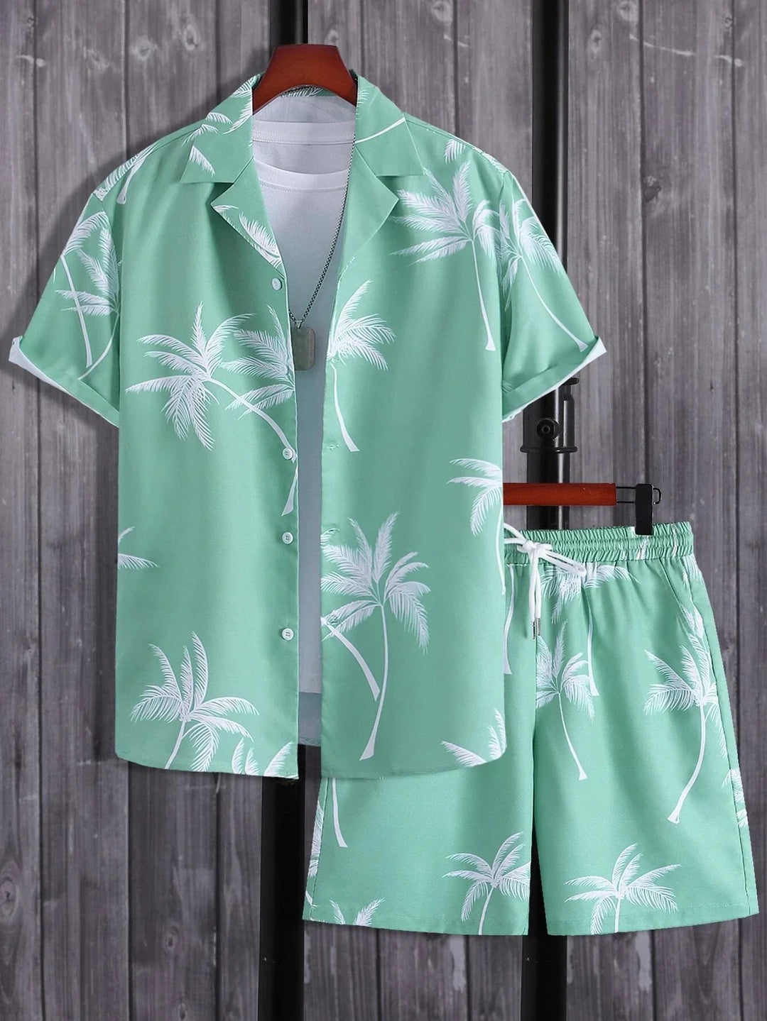 Mint green Hawaiian shirt and shorts set with white palm tree print on wooden background