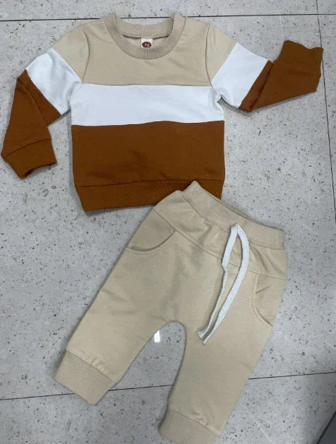 Beige, white, and brown color block long-sleeve toddler sweatshirt with beige drawstring pants on tiled floor