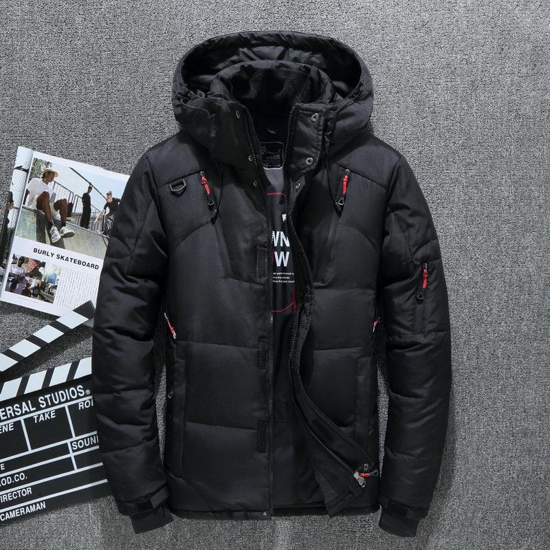 Black hooded puffer jacket with red zipper details laid on grey carpet with skateboard and film clapperboard