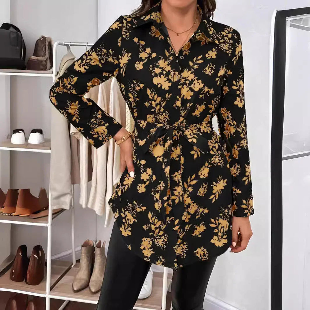 Woman wearing black long-sleeve floral tunic top with yellow flowers in modern closet