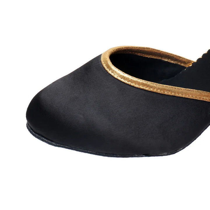 Black flat shoe with gold trim around the opening, close-up on the front part