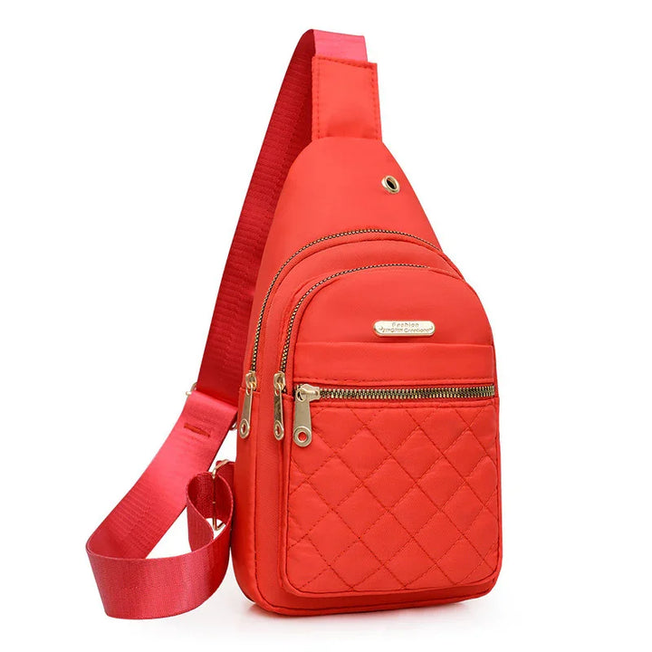 Red quilted crossbody sling bag with multiple zippered compartments and adjustable strap