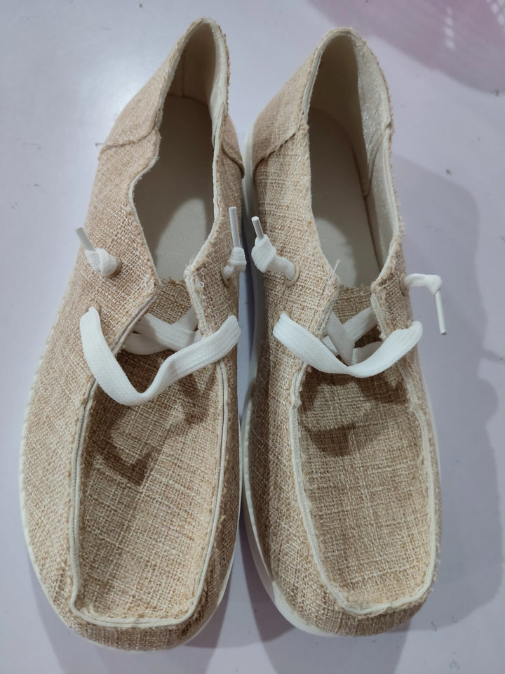 Pair of beige woven fabric casual shoes with white laces on white surface