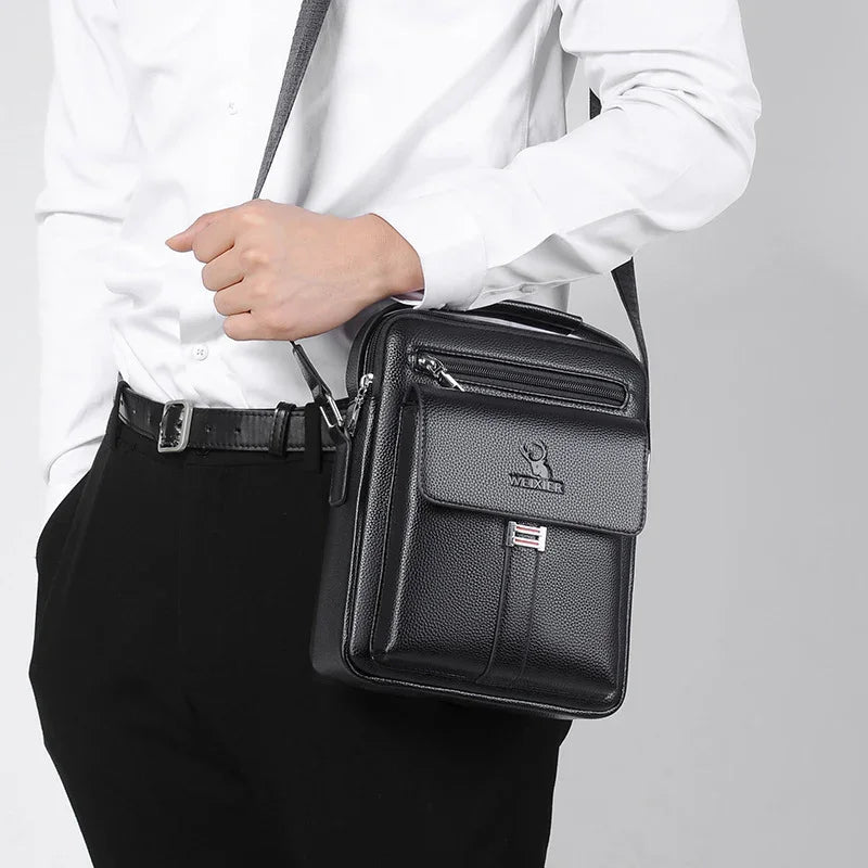 Man wearing white shirt and black pants carrying a black leather Wexler crossbody bag