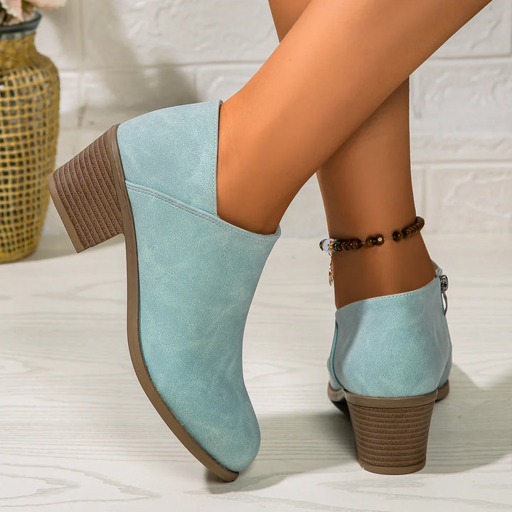 Women's stylish light blue suede ankle boots with block heels on wooden floor