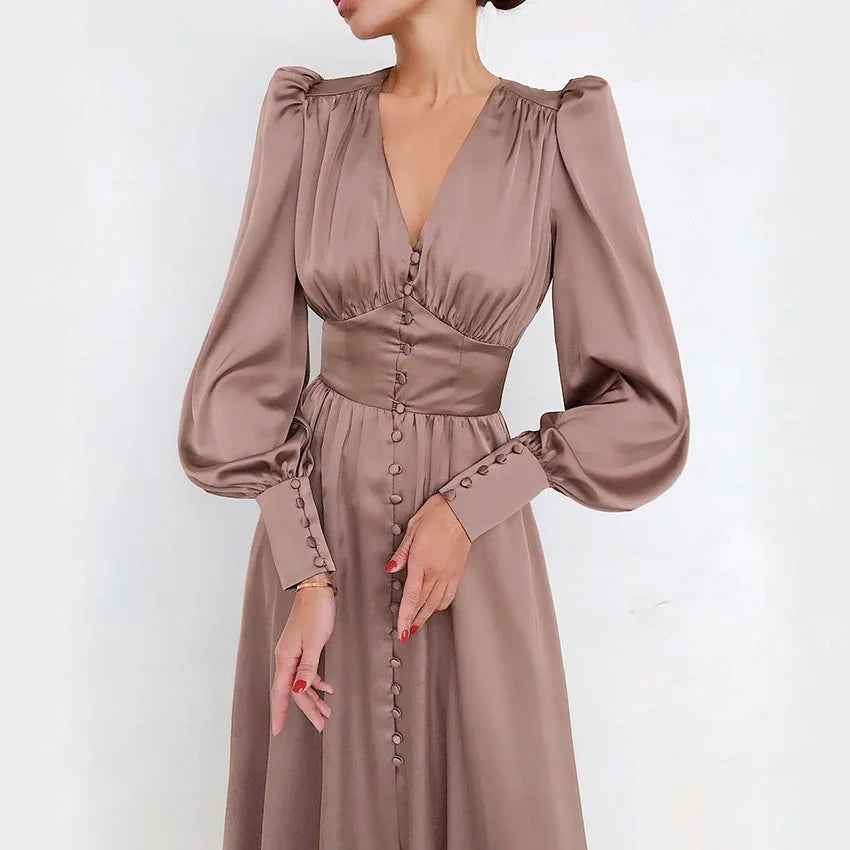 Woman wearing elegant mauve satin long sleeve dress with buttons and puffed shoulders
