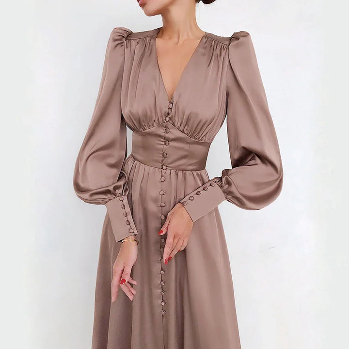Woman wearing elegant mauve satin long sleeve dress with buttons and puffed shoulders
