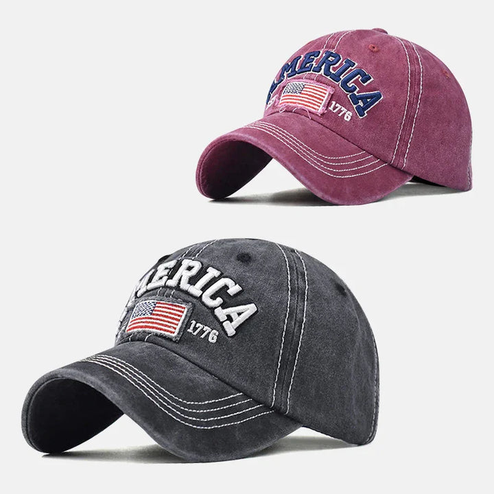 Two vintage-style baseball caps in purple and gray with America 1776 and flag embroidery