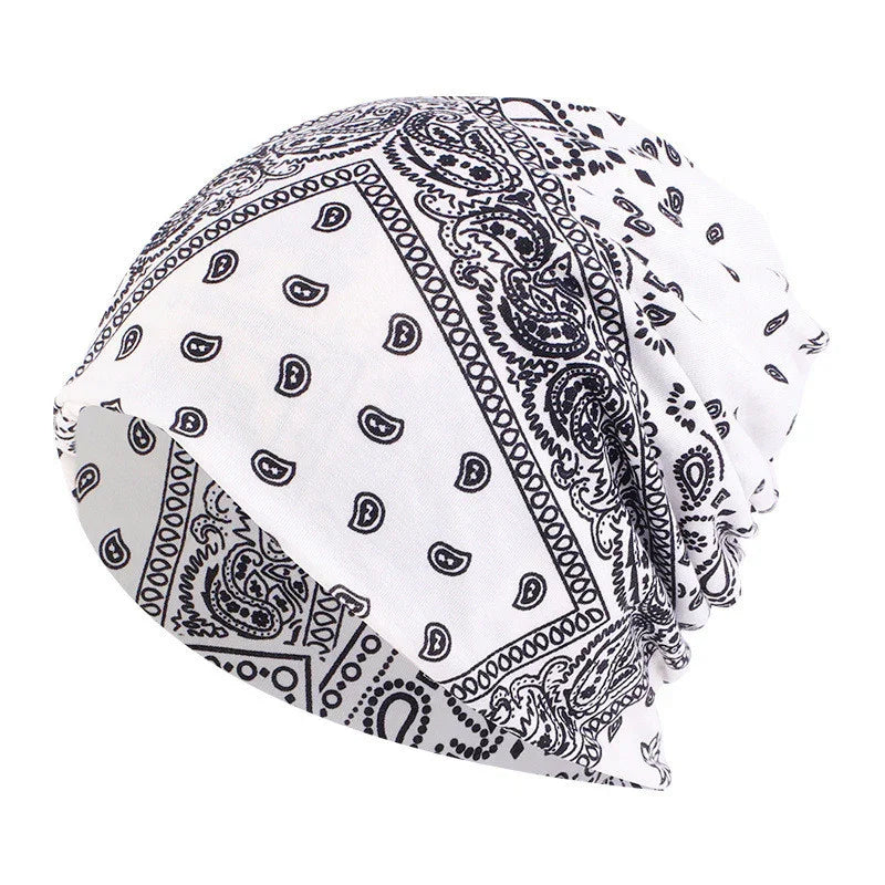 White bandana with black paisley and geometric patterns, styled as a slouchy beanie hat