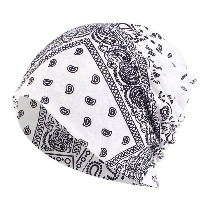 White bandana with black paisley and geometric patterns, styled as a slouchy beanie hat