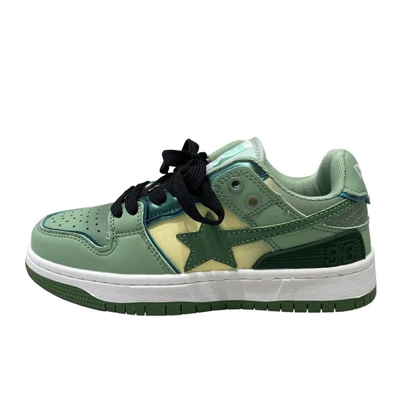 Green and cream low-top sneaker with black laces, star logo, and white sole
