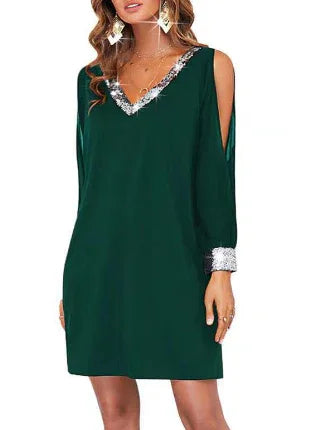 Woman wearing dark green cold shoulder mini dress with silver sequin trim on neckline and cuffs