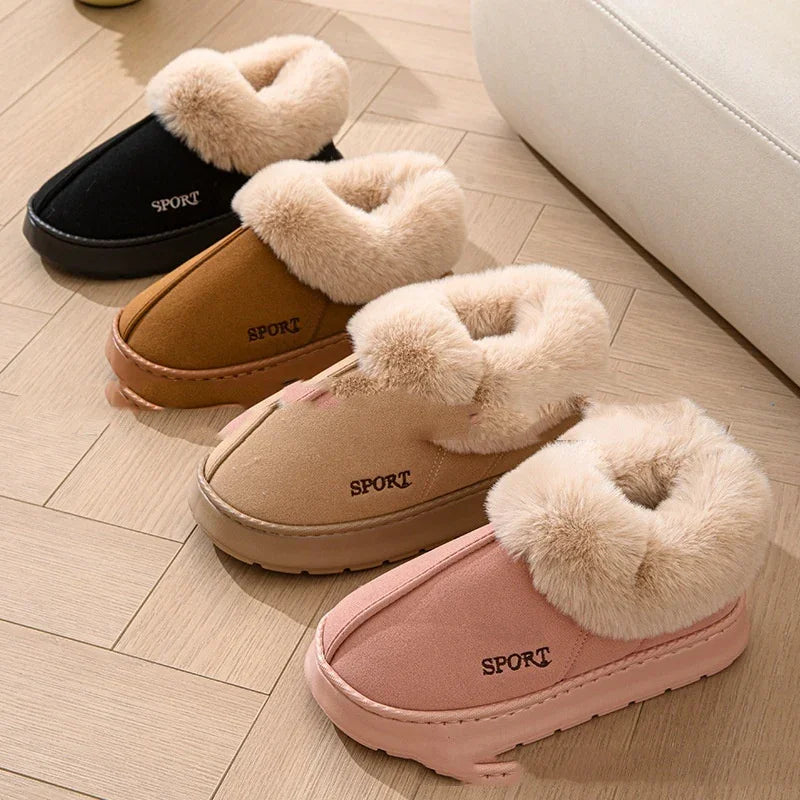 Four pairs of plush fur-lined indoor slippers in black, brown, tan, and pink on wooden floor