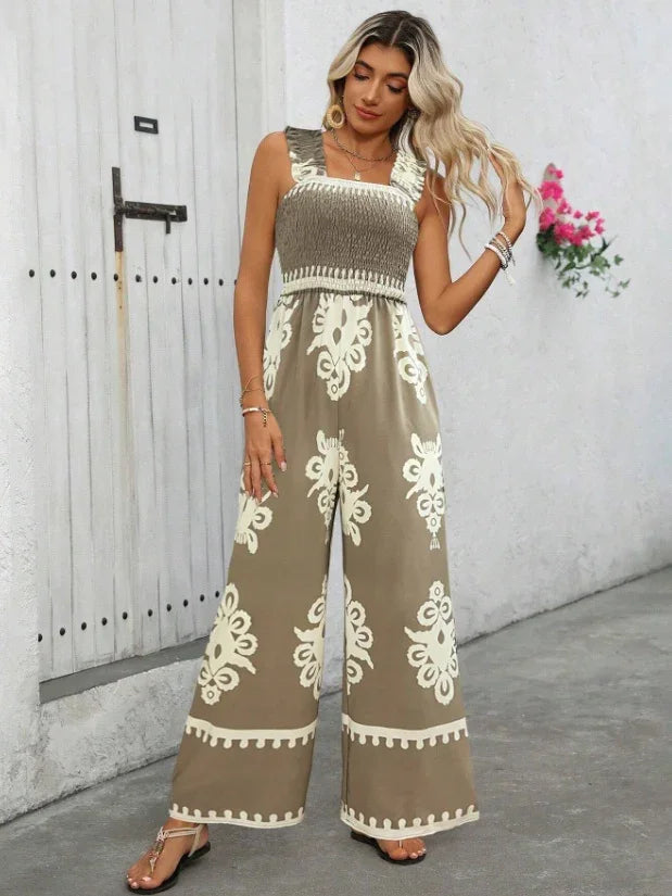 Woman wearing trendy olive green wide-leg jumpsuit with cream floral patterns and smocked bodice, standing on street