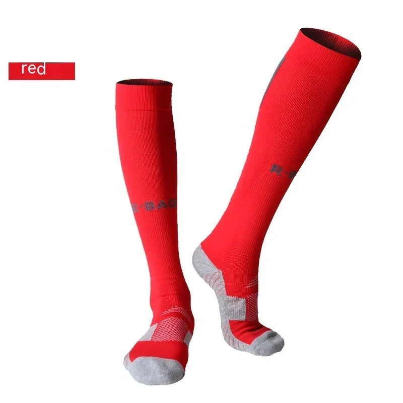 Red knee-high athletic socks with gray toes and heels on a white background
