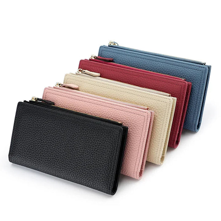 Set of five textured leather wallets in black, pink, beige, red, and blue with gold zippers