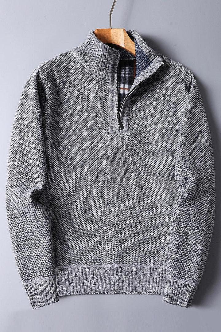 Grey textured knit sweater with quarter zipper and plaid inner collar on wooden hanger