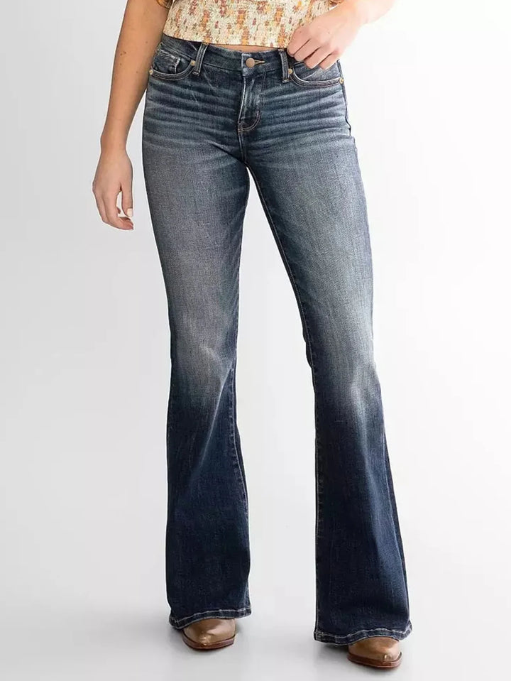Woman wearing high-waisted dark blue flare jeans with faded front and brown shoes