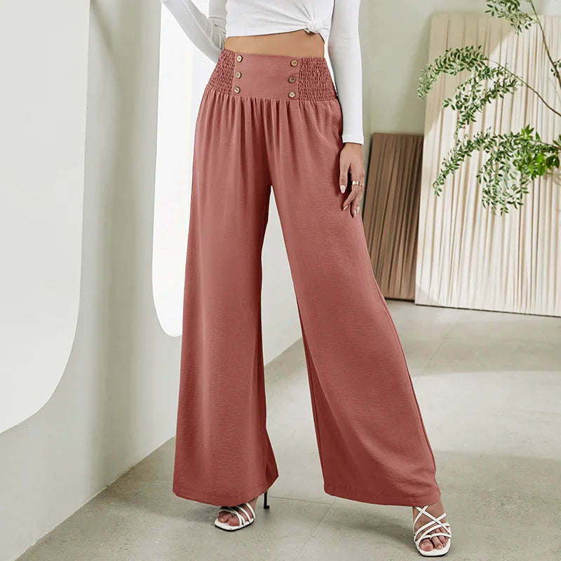 Mauve high-waisted wide-leg pants with button detail worn with white top and heels indoors