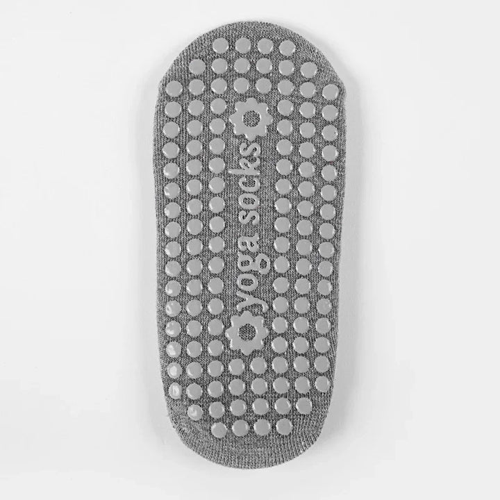 Gray yoga sock with non-slip grip dots and 'yoga socks' text with flower designs