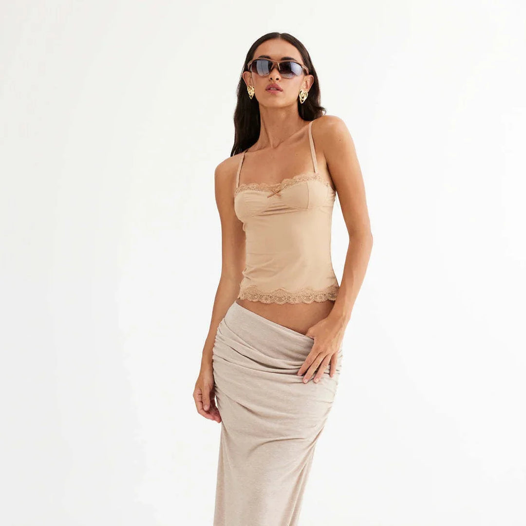 fashion model wearing beige lace-trimmed camisole top and ruched beige skirt with statement earrings and sunglasses