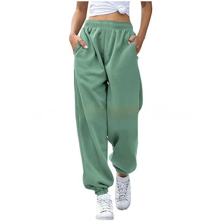 Woman wearing sage green loose fit jogger pants with elastic cuffs and white sneakers