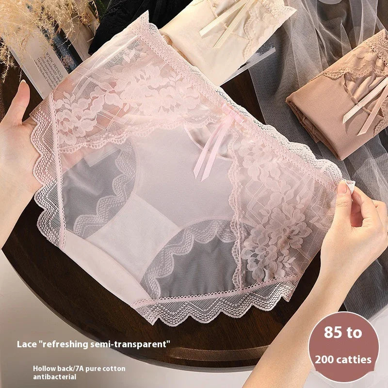 Hands holding pink lace semi-transparent women's underwear on wooden table with folded lingerie