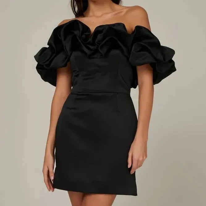 Woman wearing elegant black off-shoulder mini dress with voluminous ruffled sleeves