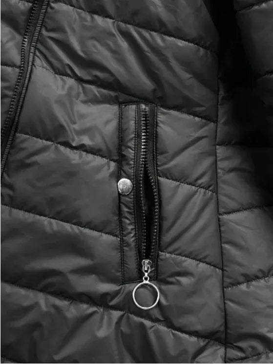 Close-up of black quilted jacket with vertical zippered pocket and silver ring pull tab