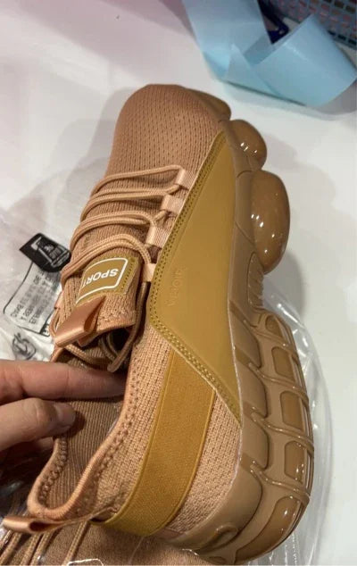 Close-up of tan sport sneaker with breathable knit upper and chunky textured sole