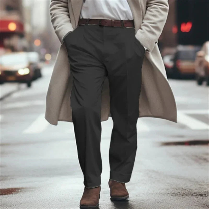 Man wearing beige coat, white shirt, black pants, and brown shoes walking on city street
