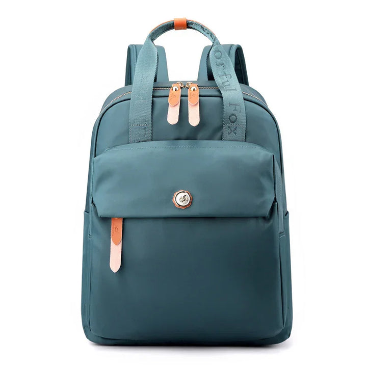 teal blue backpack with front zipper pocket, tan leather zipper pulls, and padded shoulder straps
