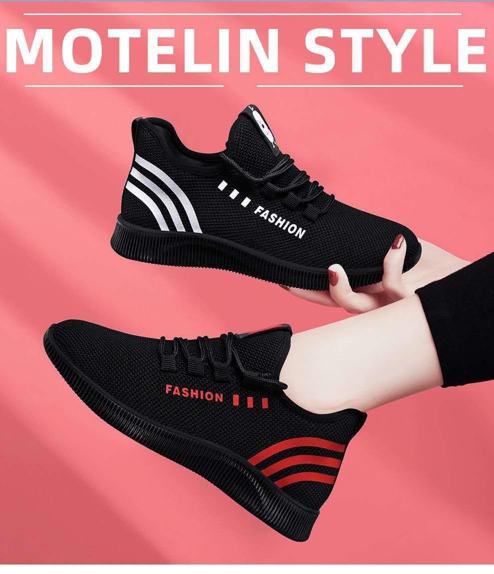 Black lightweight sport sneakers with white and red accents, stylish casual shoes on pink background