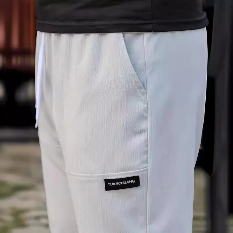 White casual pants with side pocket and black 'YUANCHUANG' label, worn with black top